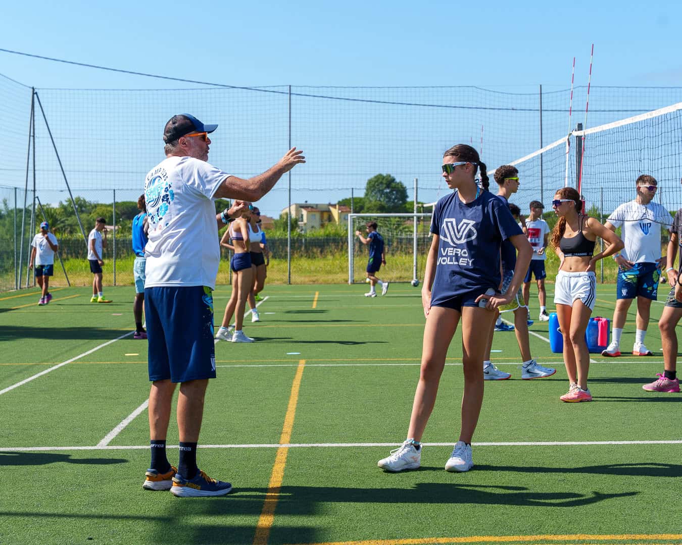 allenatore parla con giovani atleti all'aperto